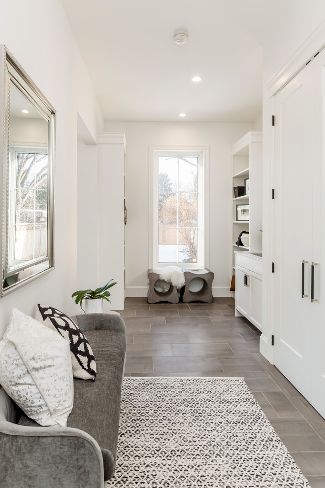 Large transitional porcelain tile mudroom photo in Other with white walls