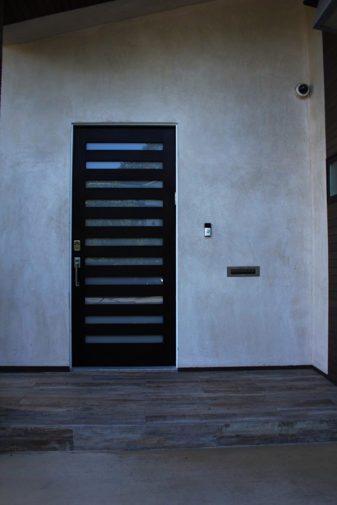 Inspiration pour une porte d'entrée minimaliste de taille moyenne avec un mur beige, parquet clair, une porte simple et une porte en bois foncé.