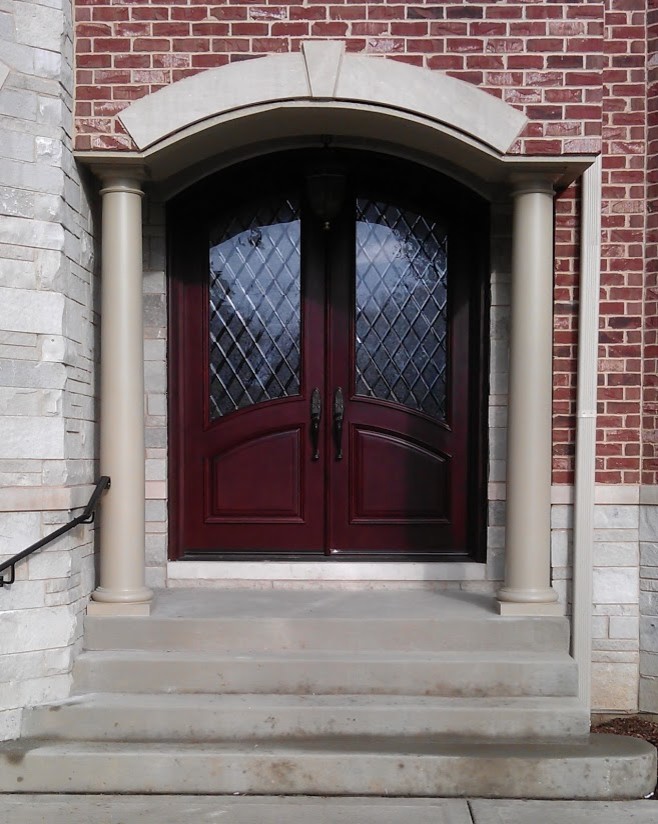 Стильный дизайн: большая входная дверь в классическом стиле с двустворчатой входной дверью и входной дверью из темного дерева - последний тренд
