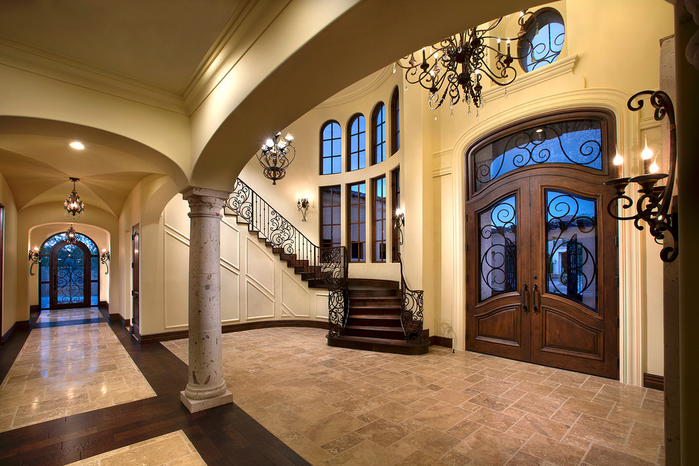 Inspiration for an expansive mediterranean foyer in Phoenix with beige walls, travertine flooring, a double front door, a brown front door and brown floors.