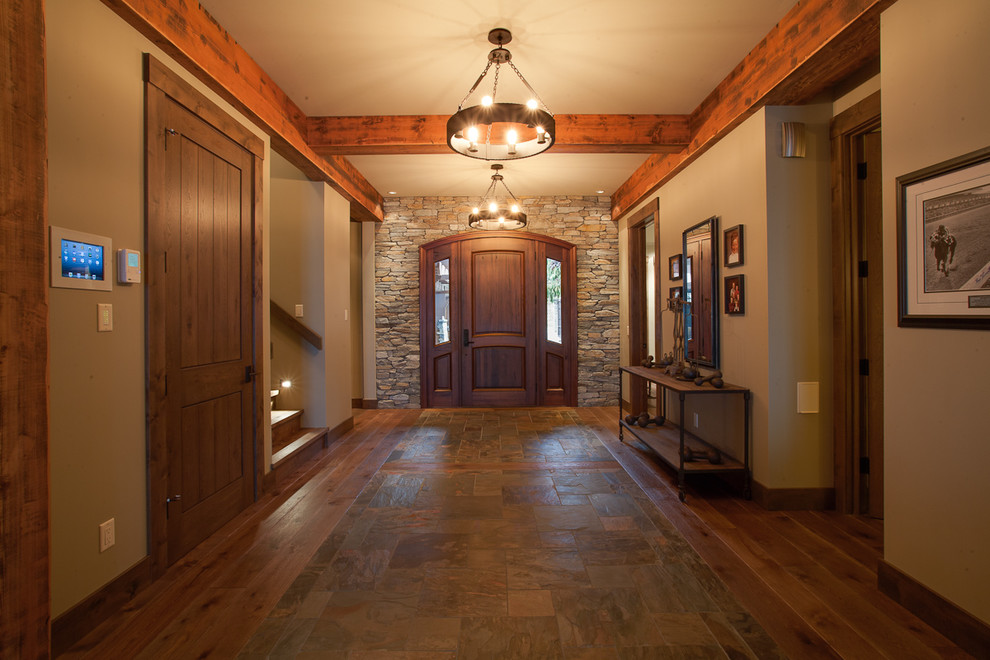 Diseño de hall rural grande con paredes grises, suelo de madera oscura, puerta simple, puerta de madera oscura y suelo marrón