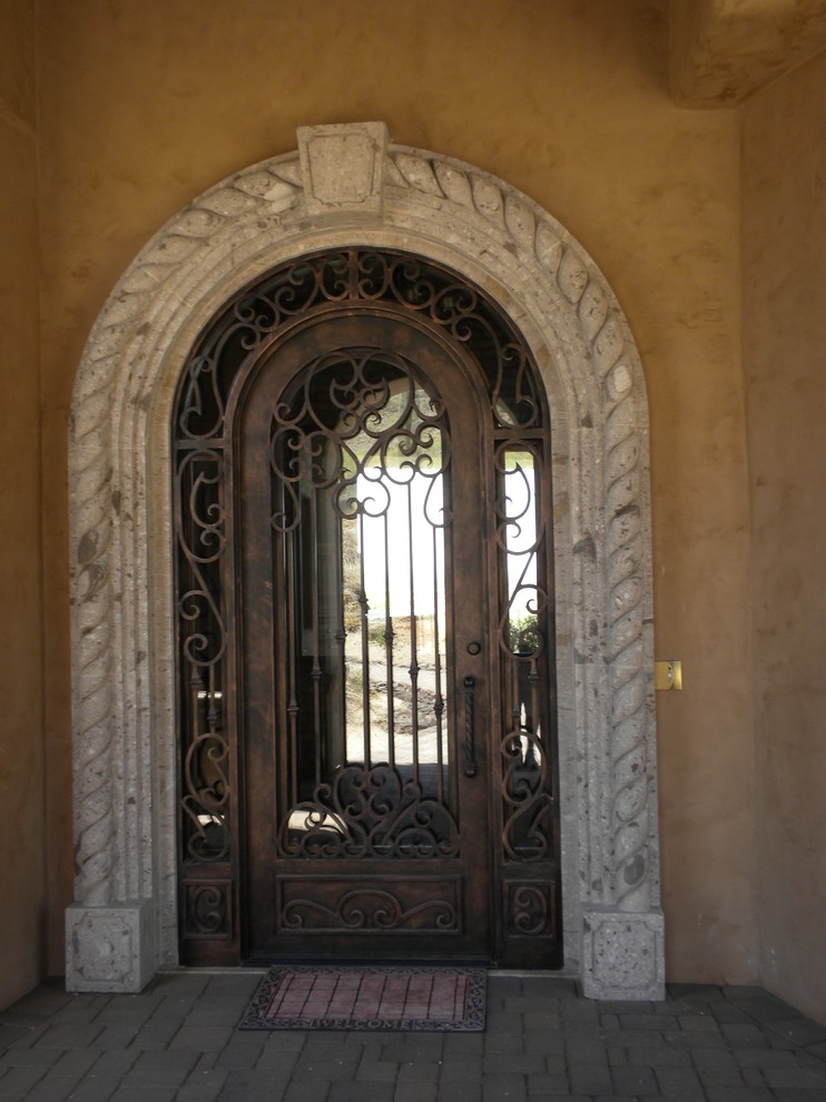 Ispirazione per una piccola porta d'ingresso mediterranea con una porta singola e una porta in metallo