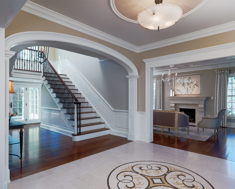 Design ideas for a large traditional foyer in Philadelphia with beige walls, dark hardwood flooring, brown floors and feature lighting.
