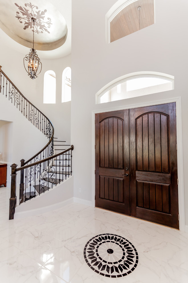 Photo of a large mediterranean foyer in Jacksonville with grey walls, marble flooring, a double front door and a dark wood front door.