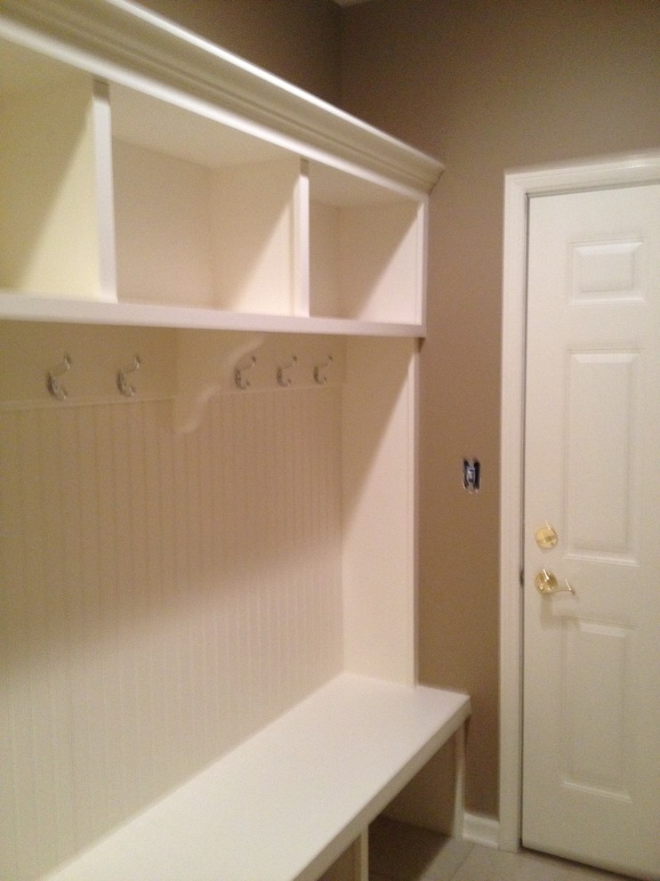 Aménagement d'une entrée craftsman de taille moyenne avec un vestiaire, un mur beige et une porte blanche.