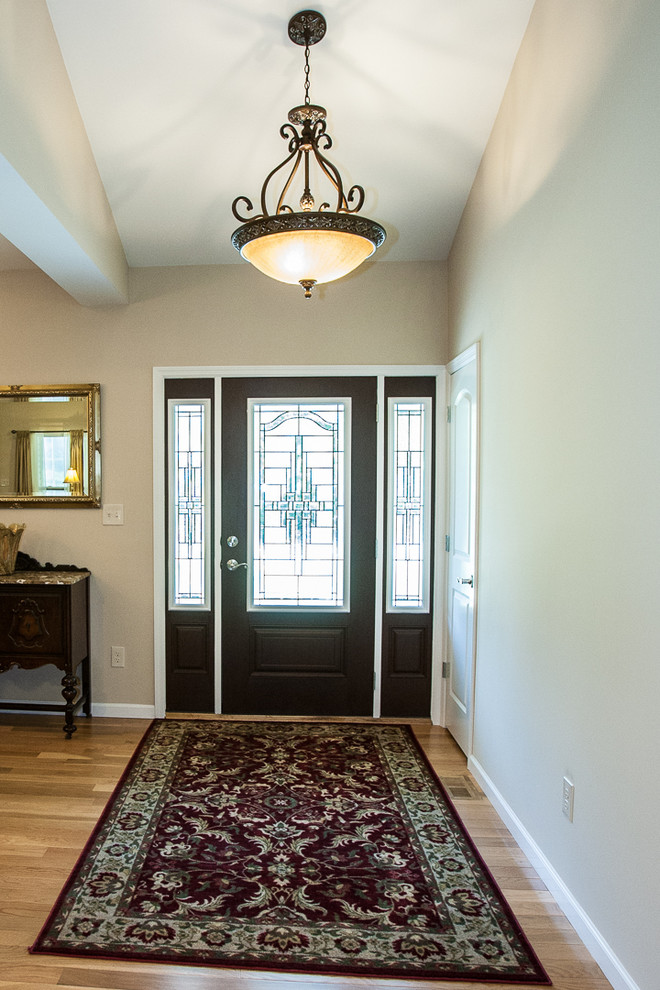 Réalisation d'une porte d'entrée craftsman de taille moyenne avec un mur beige, parquet clair, une porte simple et une porte en verre.