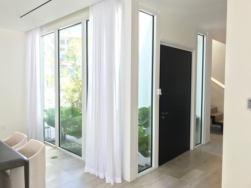 Kleine Moderne Haustür mit weißer Wandfarbe, Porzellan-Bodenfliesen, Einzeltür und schwarzer Haustür in Miami
