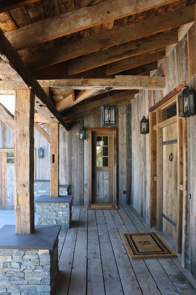 Esempio di un ingresso o corridoio rustico con pareti marroni, pavimento in legno massello medio, una porta singola, una porta in legno bruno e pavimento marrone