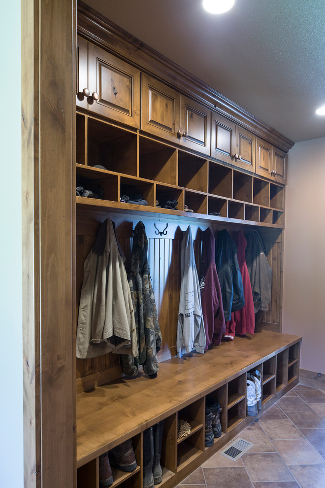 This is an example of a large rustic boot room in Wichita with beige walls, ceramic flooring and beige floors.
