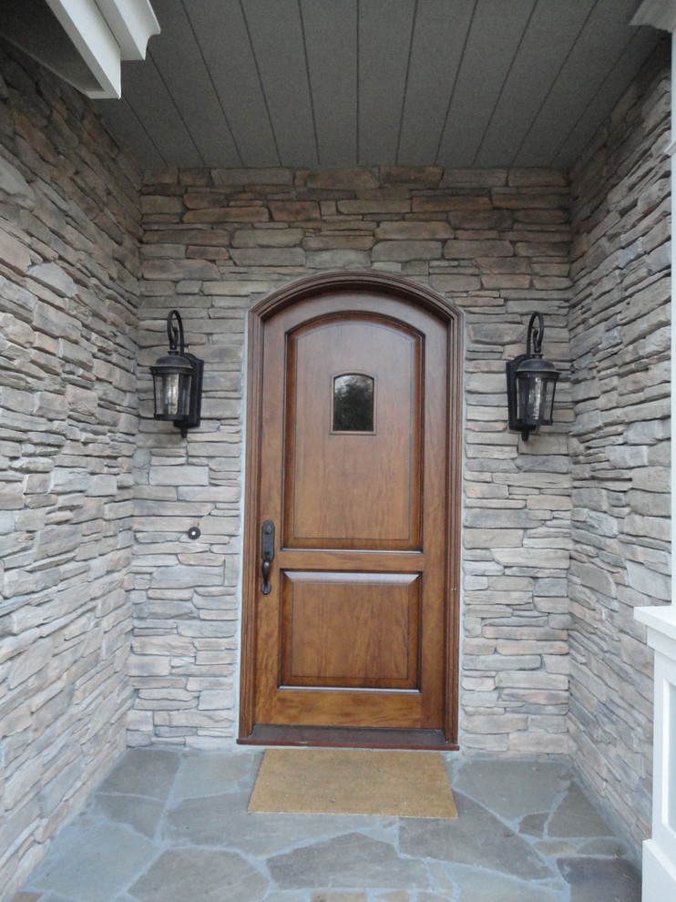 Exemple d'une porte d'entrée éclectique avec un mur gris, un sol en ardoise, une porte simple et une porte en bois brun.