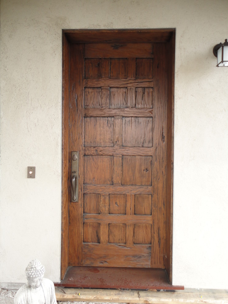 Cette image montre une porte d'entrée chalet avec une porte simple et une porte en bois brun.