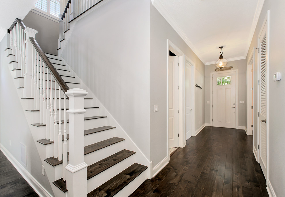 Example of a mid-sized beach style dark wood floor entryway design in Tampa with gray walls and a white front door