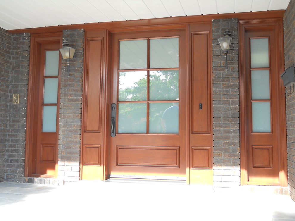 Esempio di una porta d'ingresso tradizionale di medie dimensioni con una porta singola e una porta in legno bruno