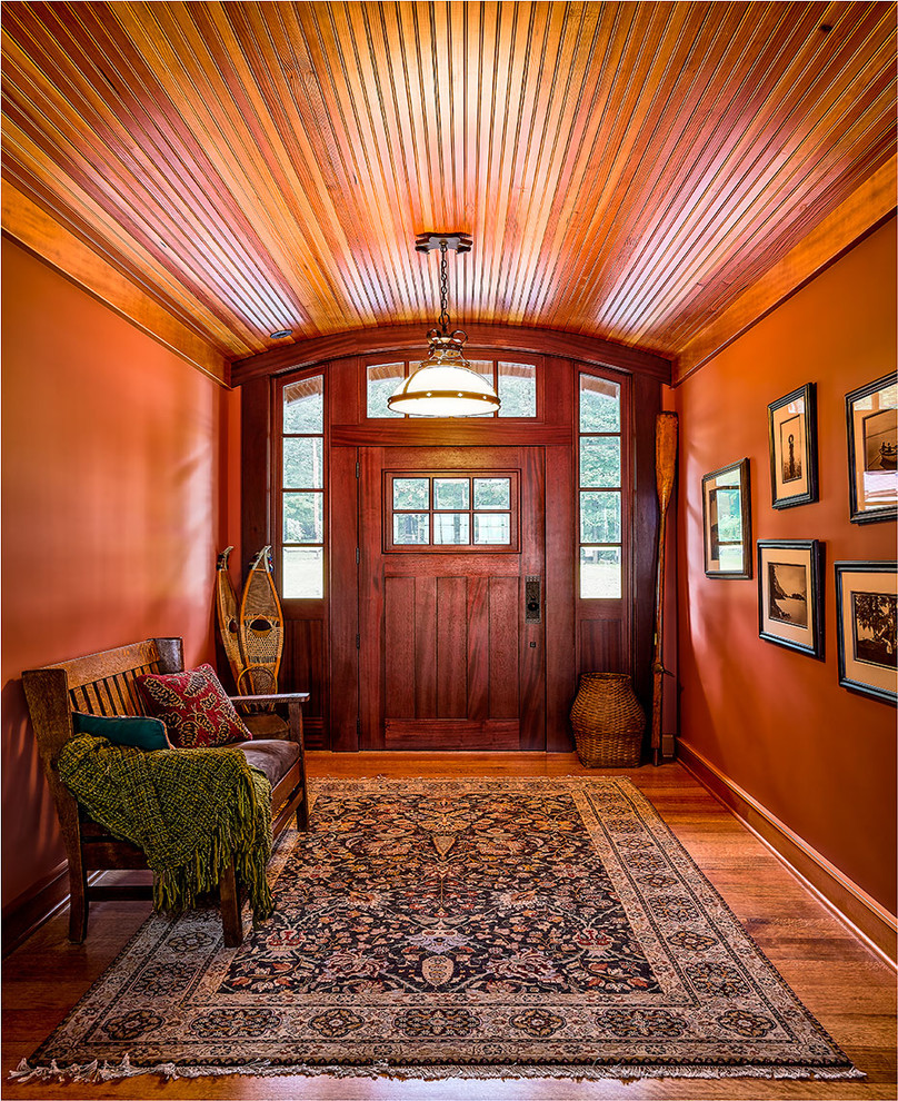 Свежая идея для дизайна: входная дверь среднего размера с оранжевыми стенами, одностворчатой входной дверью, входной дверью из темного дерева и светлым паркетным полом - отличное фото интерьера