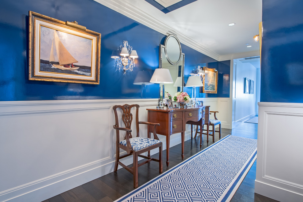 Traditional hallway in Boston with blue walls, dark hardwood flooring and brown floors.