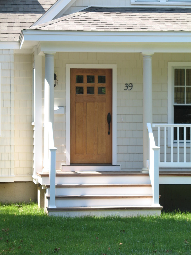 Immagine di una porta d'ingresso country di medie dimensioni con pareti beige, una porta singola e una porta in legno chiaro