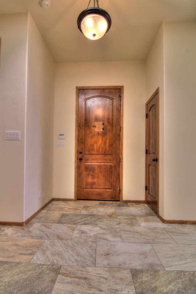 Immagine di una piccola porta d'ingresso mediterranea con pareti marroni, pavimento con piastrelle in ceramica, una porta singola e una porta in legno bruno