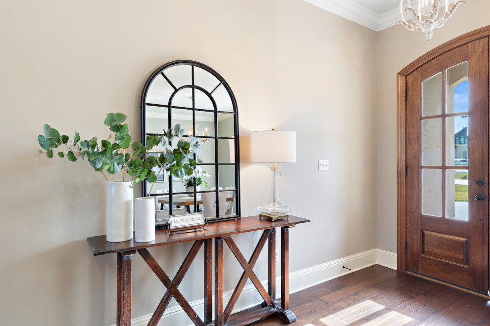 This is an example of a medium sized traditional hallway in New Orleans with beige walls, medium hardwood flooring, a double front door, a medium wood front door and brown floors.