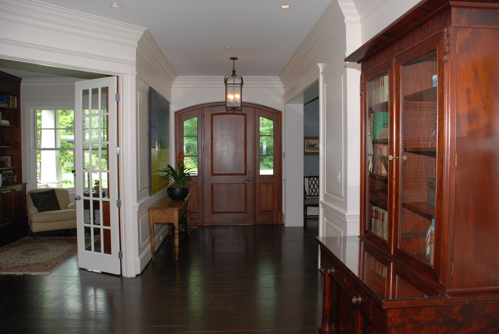 Esempio di una grande porta d'ingresso chic con una porta singola, pareti bianche, parquet scuro e una porta in legno bruno