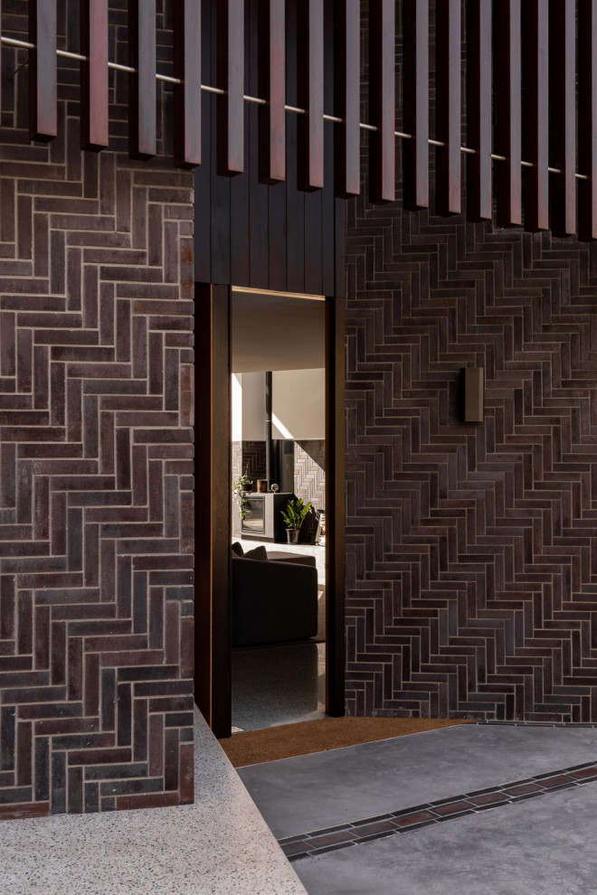 Modern front door in Perth with brown walls, concrete flooring, a dark wood front door and grey floors.