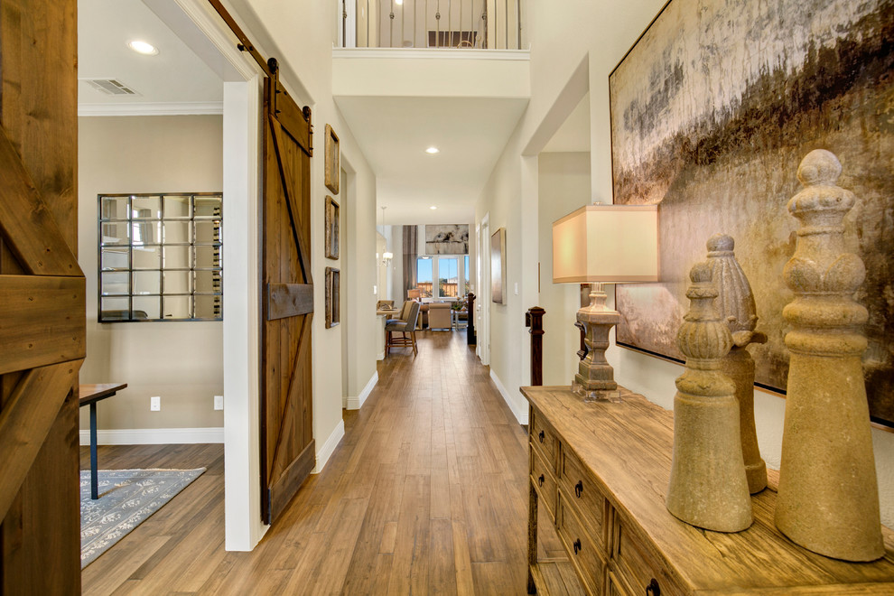 Inspiration pour une grande entrée avec un couloir, un mur beige, un sol en bois brun et une porte simple.