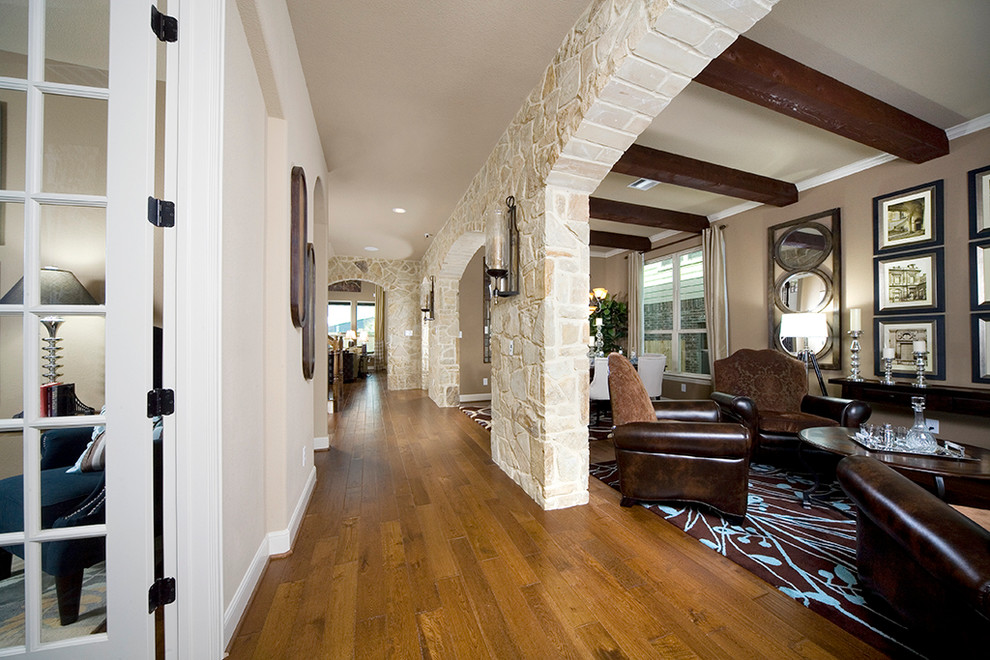 Inspiration pour une grande entrée traditionnelle avec un couloir, un mur beige et un sol en bois brun.