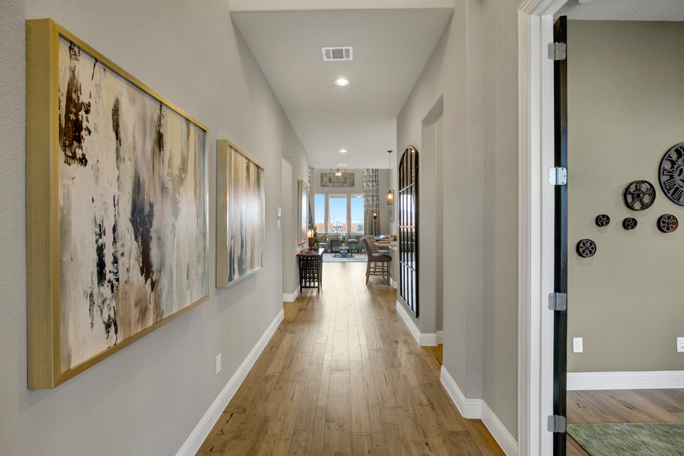 Hallway - large transitional light wood floor and brown floor hallway idea in Dallas with gray walls