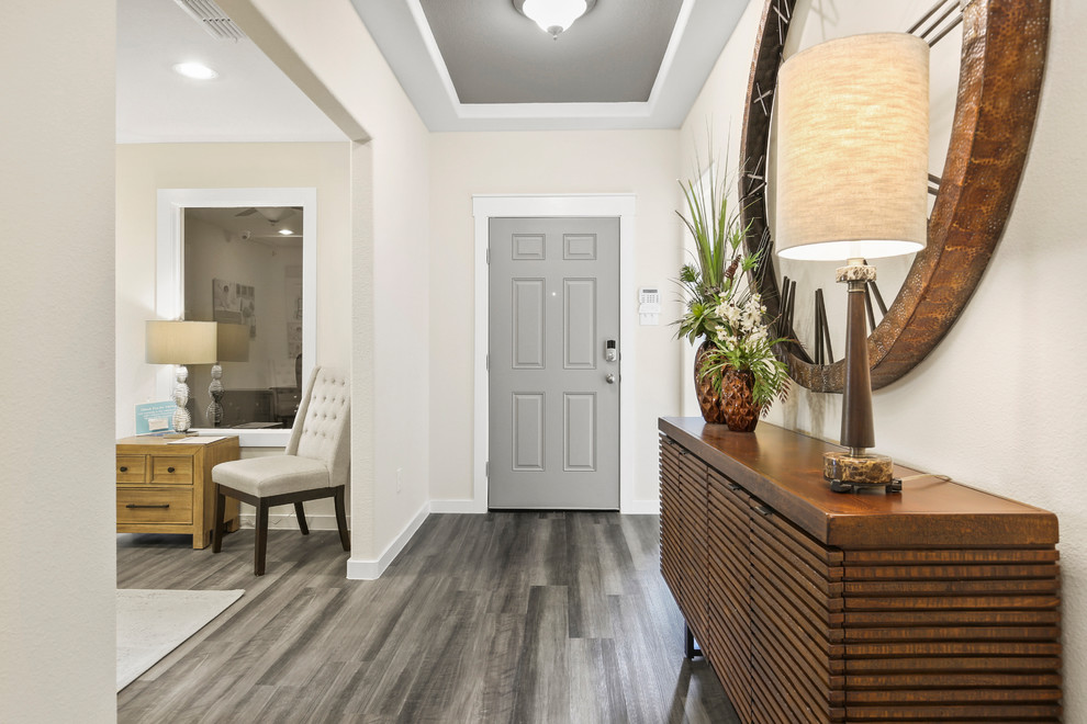 Idée de décoration pour une entrée design de taille moyenne avec un couloir, un mur beige, parquet foncé, une porte simple, une porte grise et un sol gris.