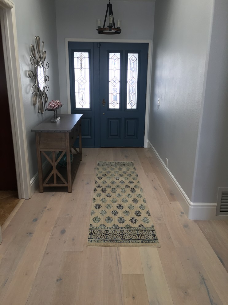 Mittelgroßer Maritimer Eingang mit Korridor, blauer Wandfarbe, hellem Holzboden, Einzeltür und blauer Haustür in Orange County