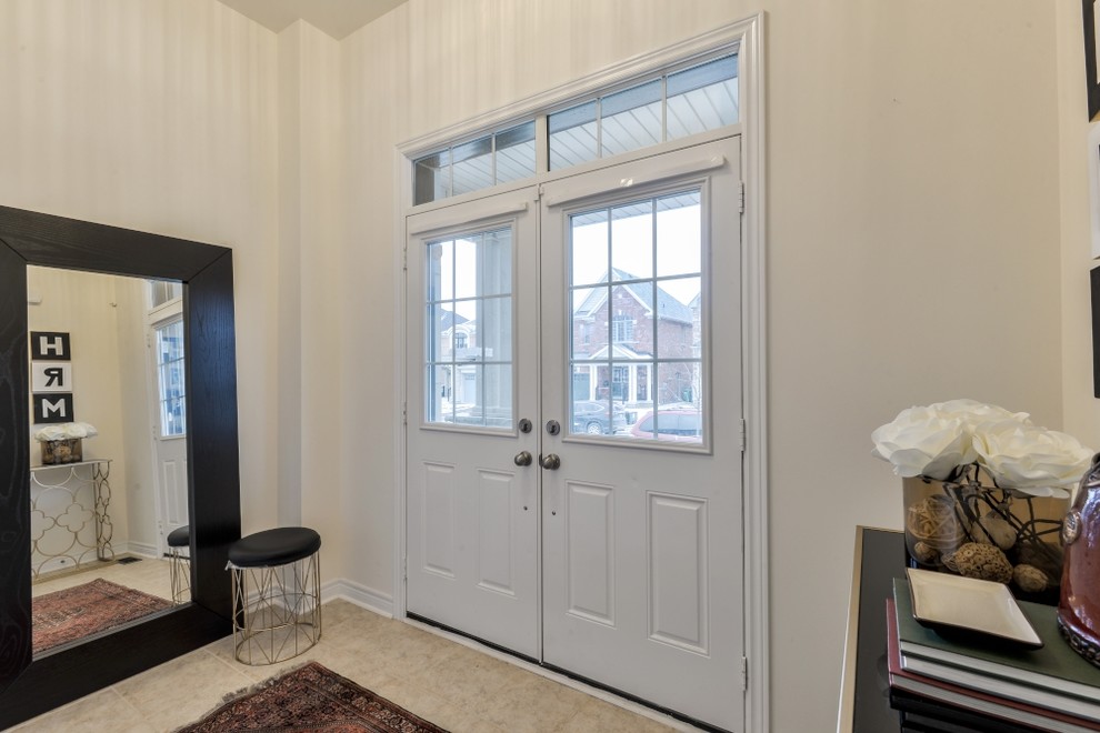 Photo of a medium sized traditional foyer in Toronto with beige walls, porcelain flooring, a double front door and a white front door.