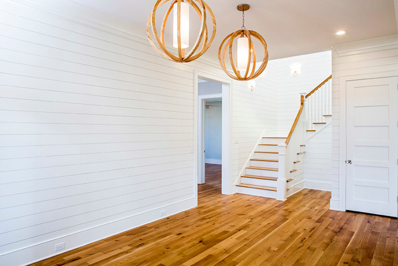 Large transitional light wood floor entryway photo in Charleston with white walls and a dark wood front door
