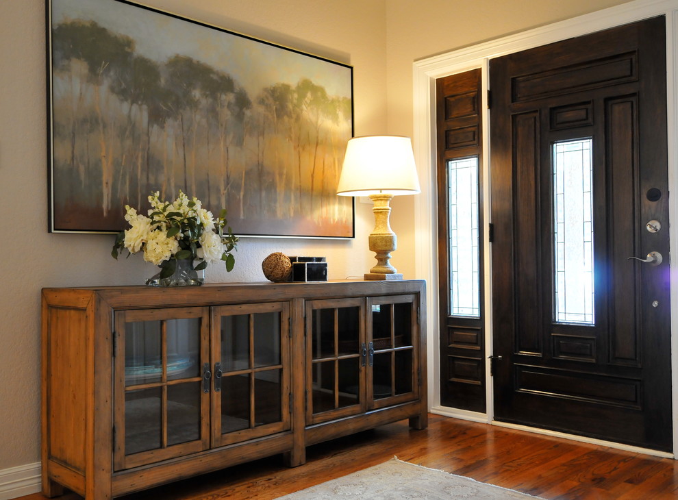 Mid-sized elegant medium tone wood floor entryway photo in Austin with beige walls and a black front door