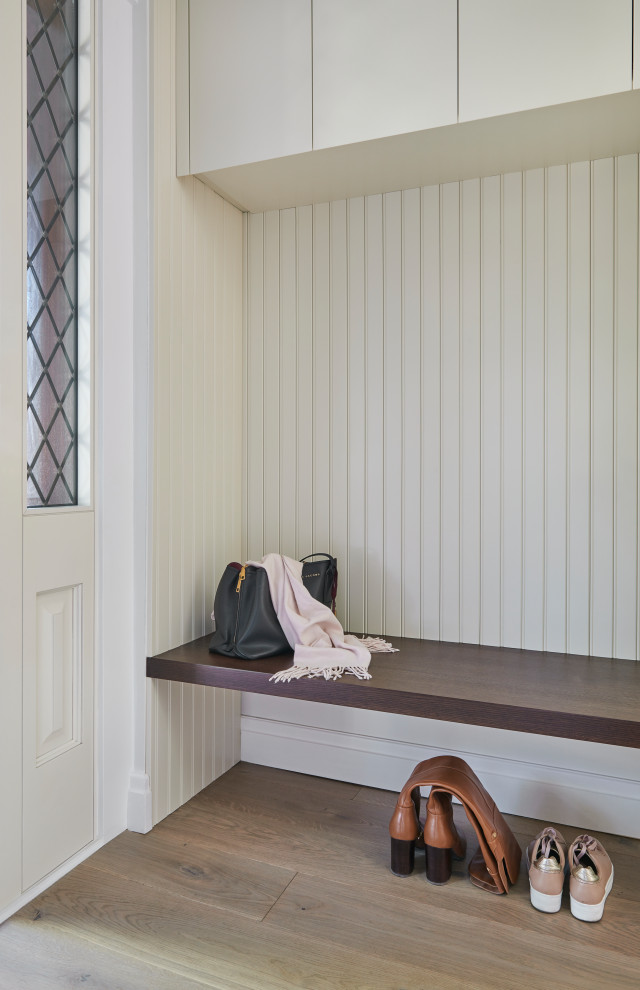 ローリーにあるお手頃価格の小さなトラディショナルスタイルのおしゃれな玄関ロビー (白い壁、淡色無垢フローリング、濃色木目調のドア、ベージュの床) の写真
