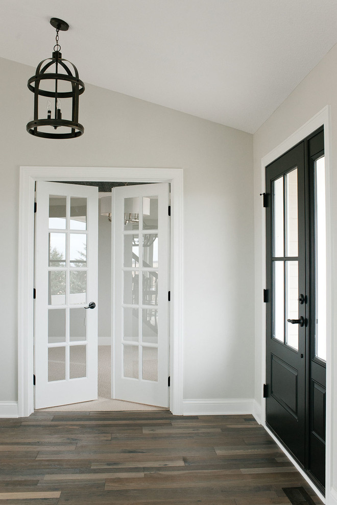 Inspiration för mellanstora klassiska foajéer, med grå väggar, mellanmörkt trägolv, en enkeldörr, en svart dörr och brunt golv