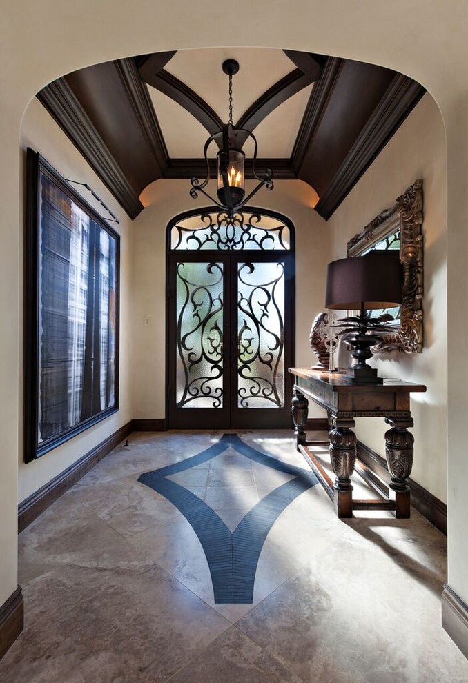 フェニックスにあるラグジュアリーな広い地中海スタイルのおしゃれな玄関ロビー (白い壁、トラバーチンの床、茶色いドア、ベージュの床) の写真