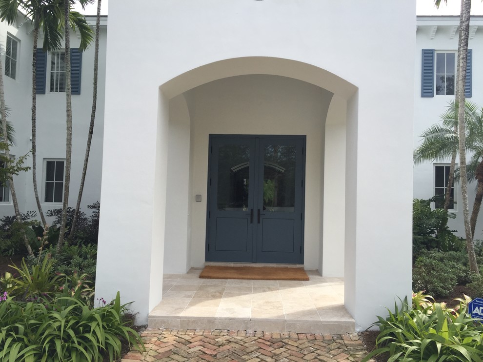 На фото: входная дверь среднего размера в стиле неоклассика (современная классика) с белыми стенами, полом из керамогранита, двустворчатой входной дверью и синей входной дверью с