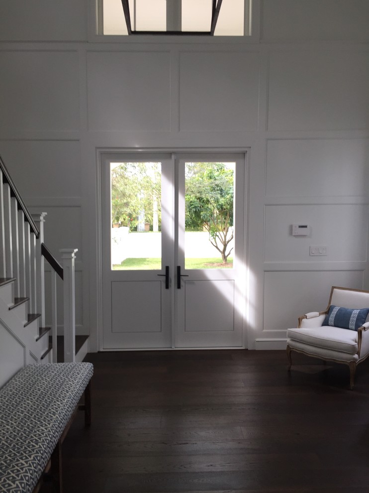 Стильный дизайн: входная дверь среднего размера в стиле неоклассика (современная классика) с белыми стенами, темным паркетным полом, двустворчатой входной дверью и белой входной дверью - последний тренд