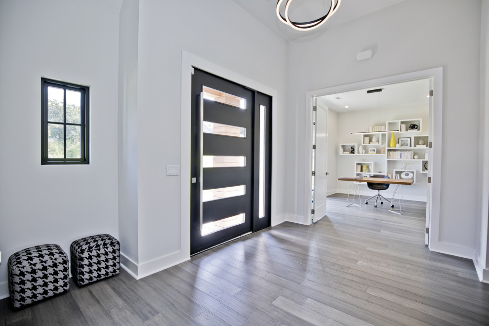 Пример оригинального дизайна: фойе среднего размера в современном стиле с белыми стенами, поворотной входной дверью, черной входной дверью, серым полом и полом из винила
