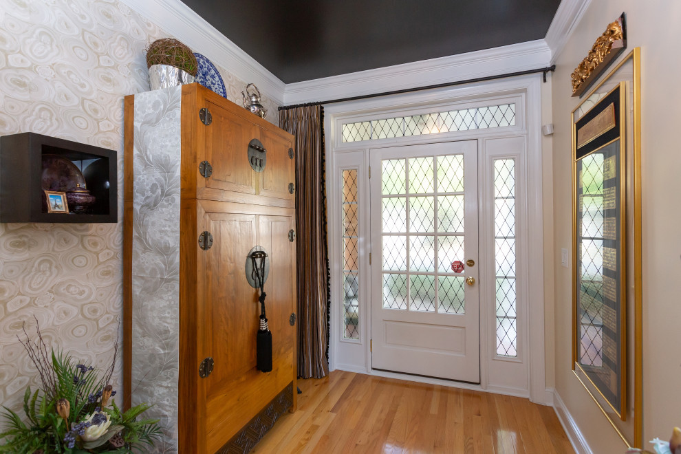 Medium sized eclectic front door in Raleigh with beige walls, light hardwood flooring, a single front door, a white front door, brown floors and wallpapered walls.