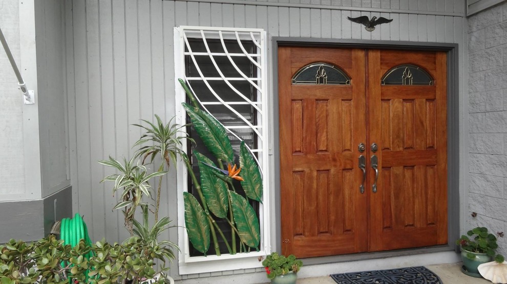 Imagen de entrada exótica con puerta doble y puerta de madera en tonos medios