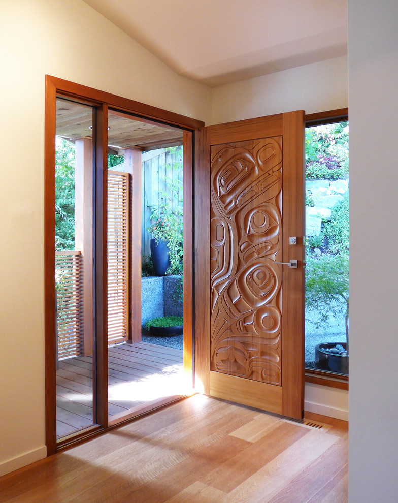 Aménagement d'une petite porte d'entrée contemporaine avec un mur blanc, un sol en bois brun, une porte simple et une porte en bois brun.