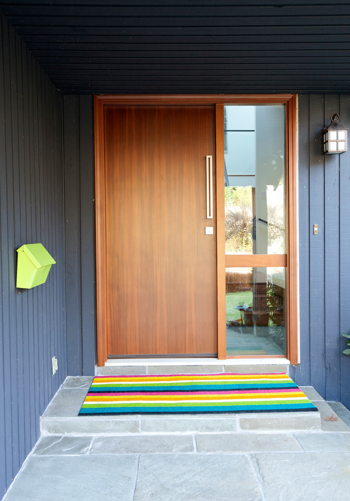 Foto di una grande porta d'ingresso minimal con pavimento in ardesia, una porta a pivot e una porta in legno bruno
