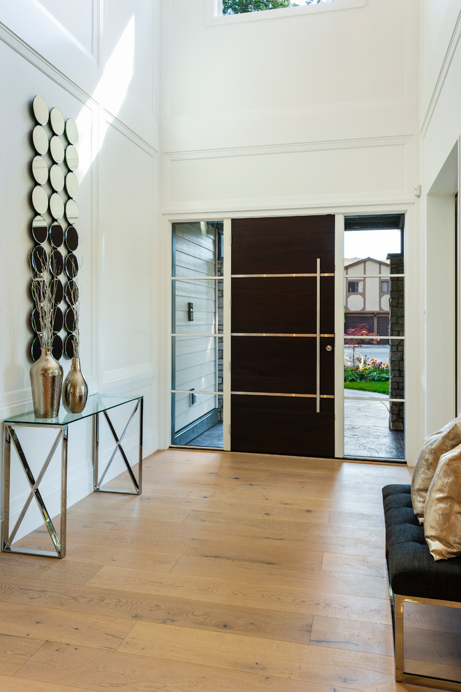バンクーバーにある高級な中くらいなトランジショナルスタイルのおしゃれな玄関ロビー (白い壁、淡色無垢フローリング、濃色木目調のドア、ベージュの床) の写真