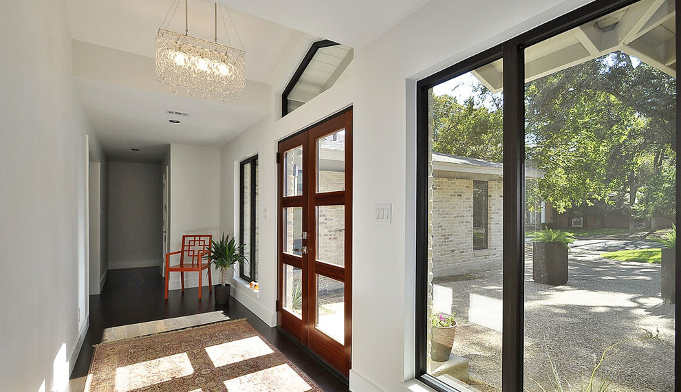 Idée de décoration pour une entrée design avec un couloir, un mur blanc, parquet foncé, une porte double et une porte en verre.