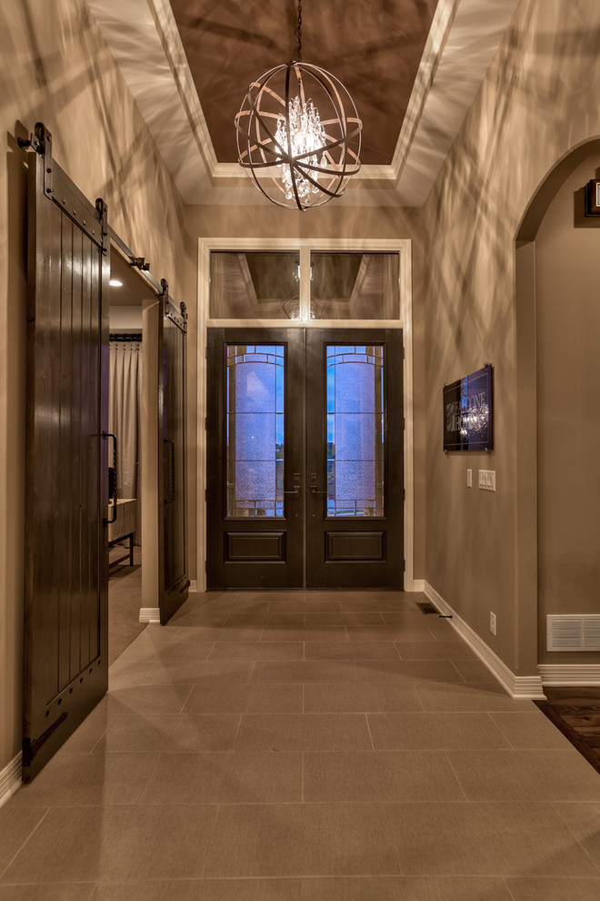 Ejemplo de puerta principal clásica de tamaño medio con paredes marrones, suelo de baldosas de porcelana, puerta doble, puerta de madera oscura y suelo marrón