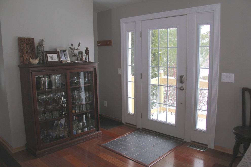 Foto de puerta principal clásica pequeña con paredes grises, suelo de baldosas de porcelana, puerta simple y puerta blanca