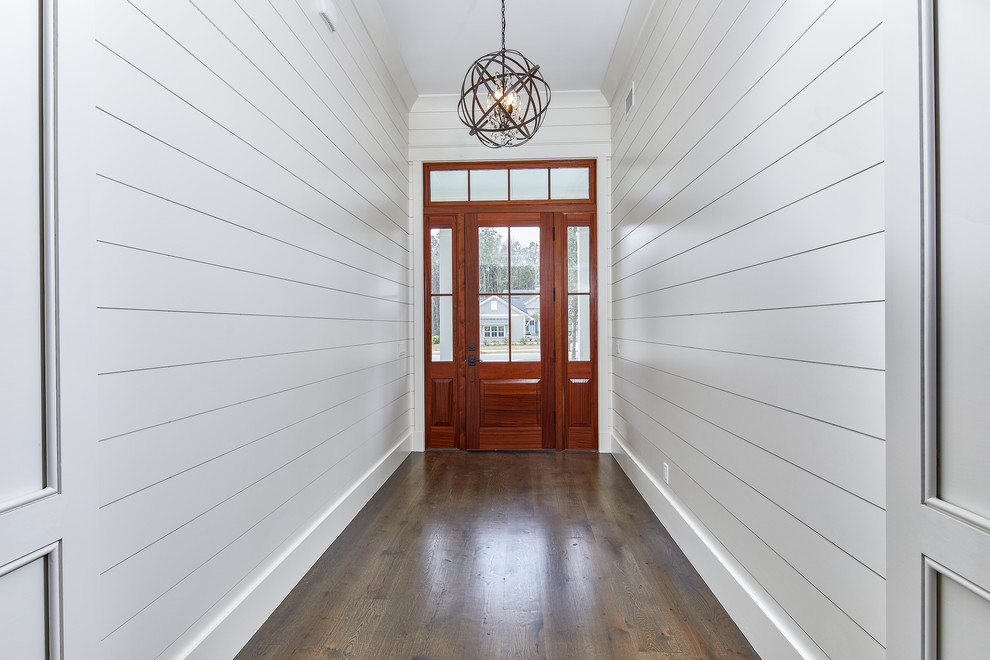 Große Stilmix Haustür mit Einzeltür, dunkler Holzhaustür, braunem Boden, weißer Wandfarbe und dunklem Holzboden in Charleston