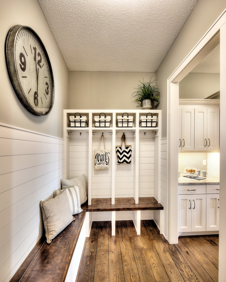 Ispirazione per un ingresso con anticamera tradizionale con pareti beige, pavimento in legno massello medio e pavimento marrone