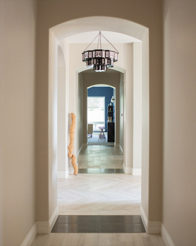 Idee per un grande corridoio boho chic con pareti beige, pavimento con piastrelle in ceramica, una porta singola e una porta in legno scuro