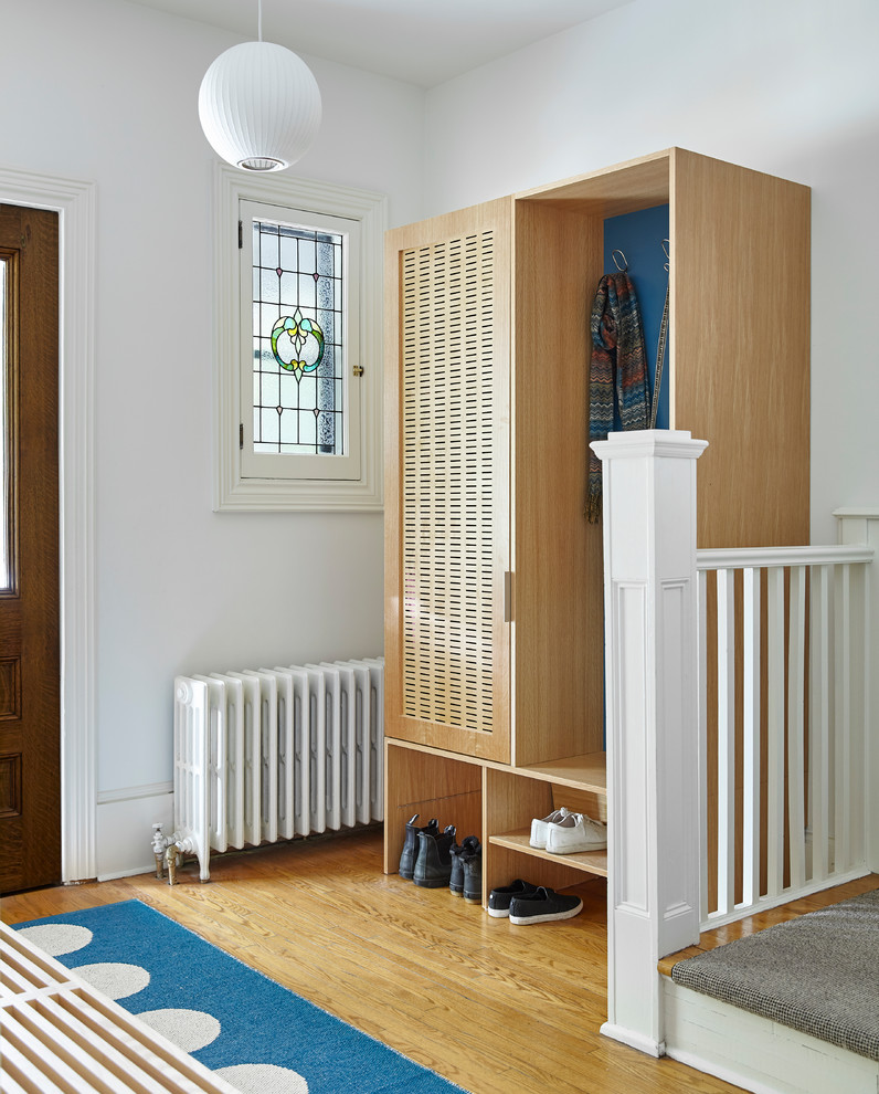 Exempel på en mellanstor minimalistisk foajé, med vita väggar, ljust trägolv, en enkeldörr, mörk trädörr och beiget golv